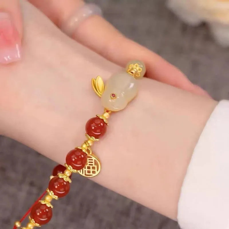 A Chinese style glass bracelet with bamboo leaf and bead designs on a wrist.