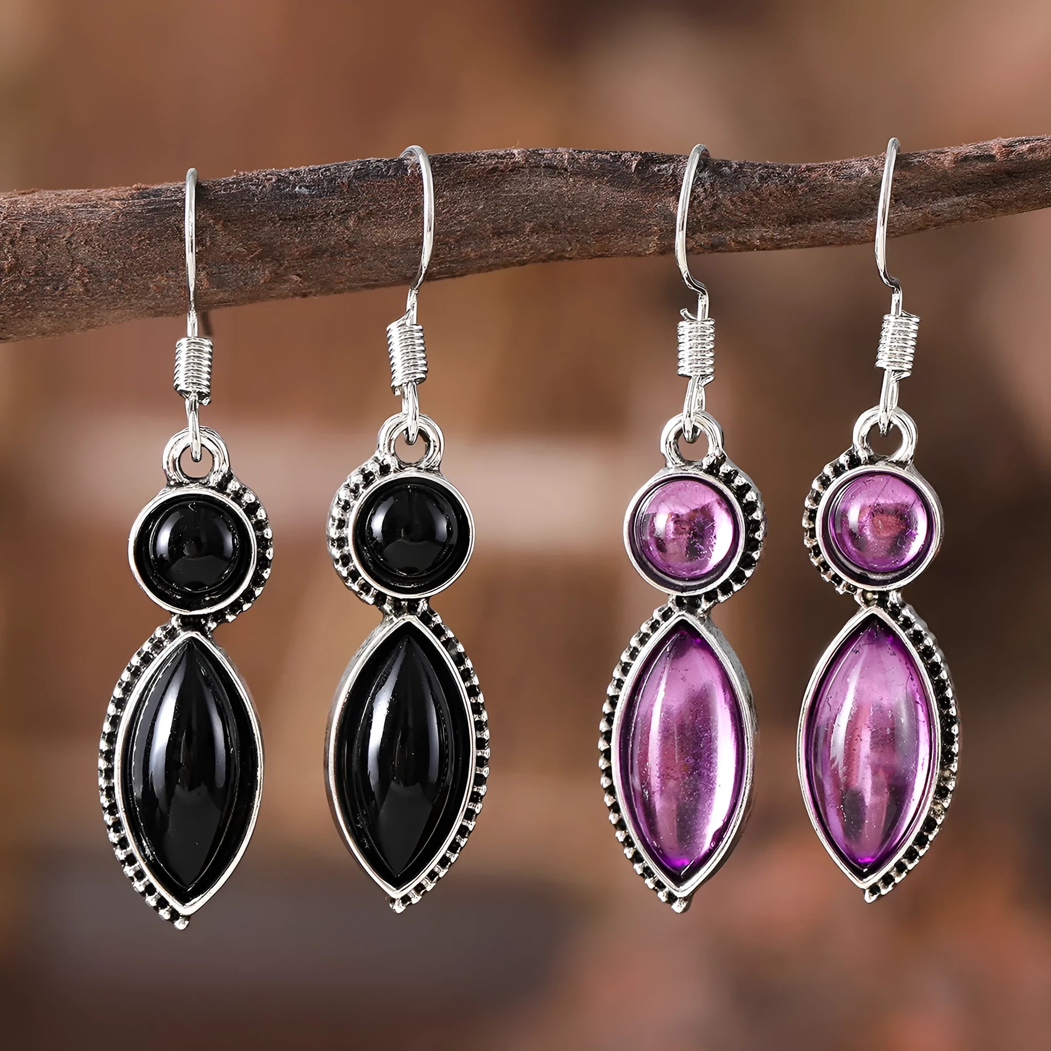A pair of vintage geometric drop earrings with black and purple stones in a bohemian style.