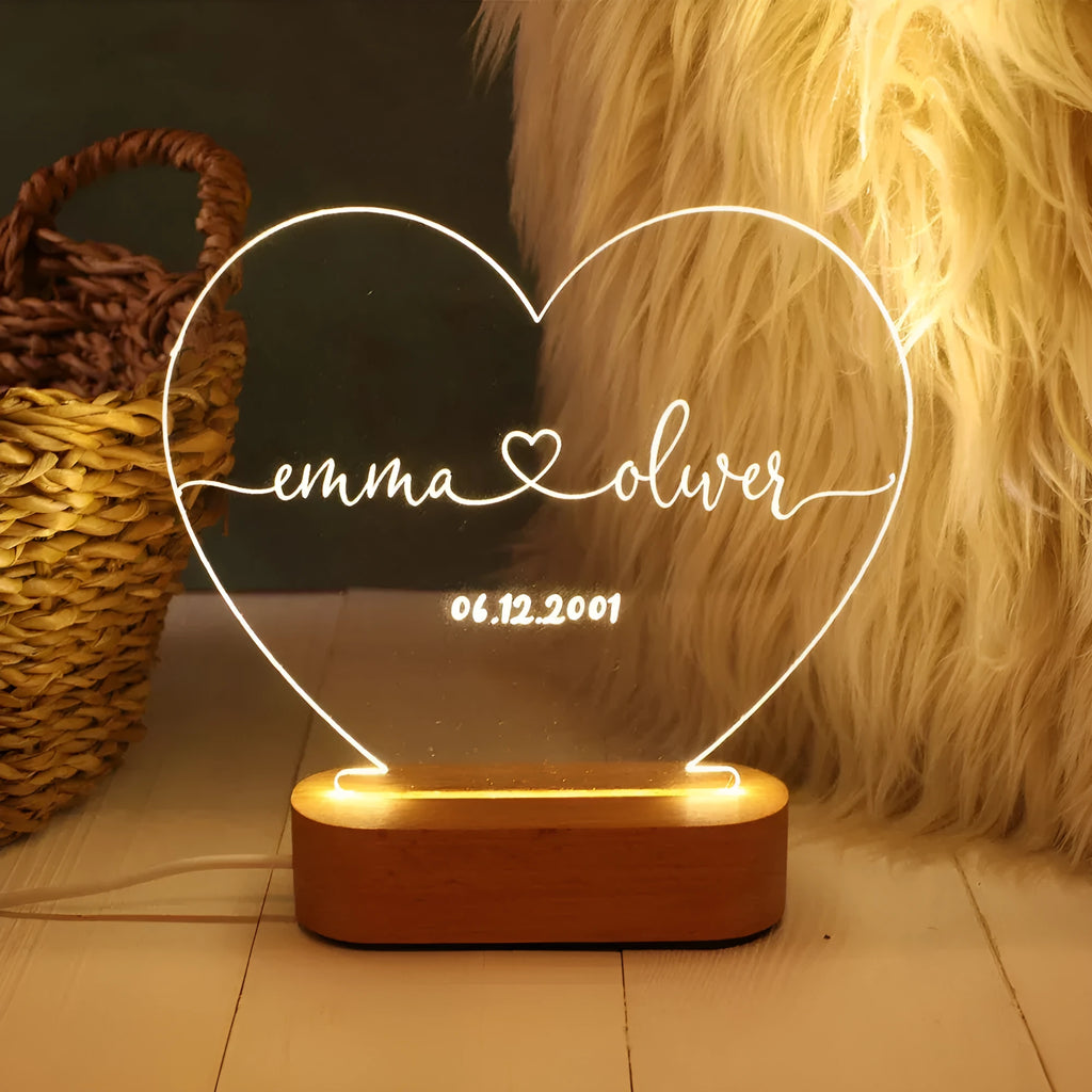 Custom clear acrylic night light with engraved names, lit by an LED base.