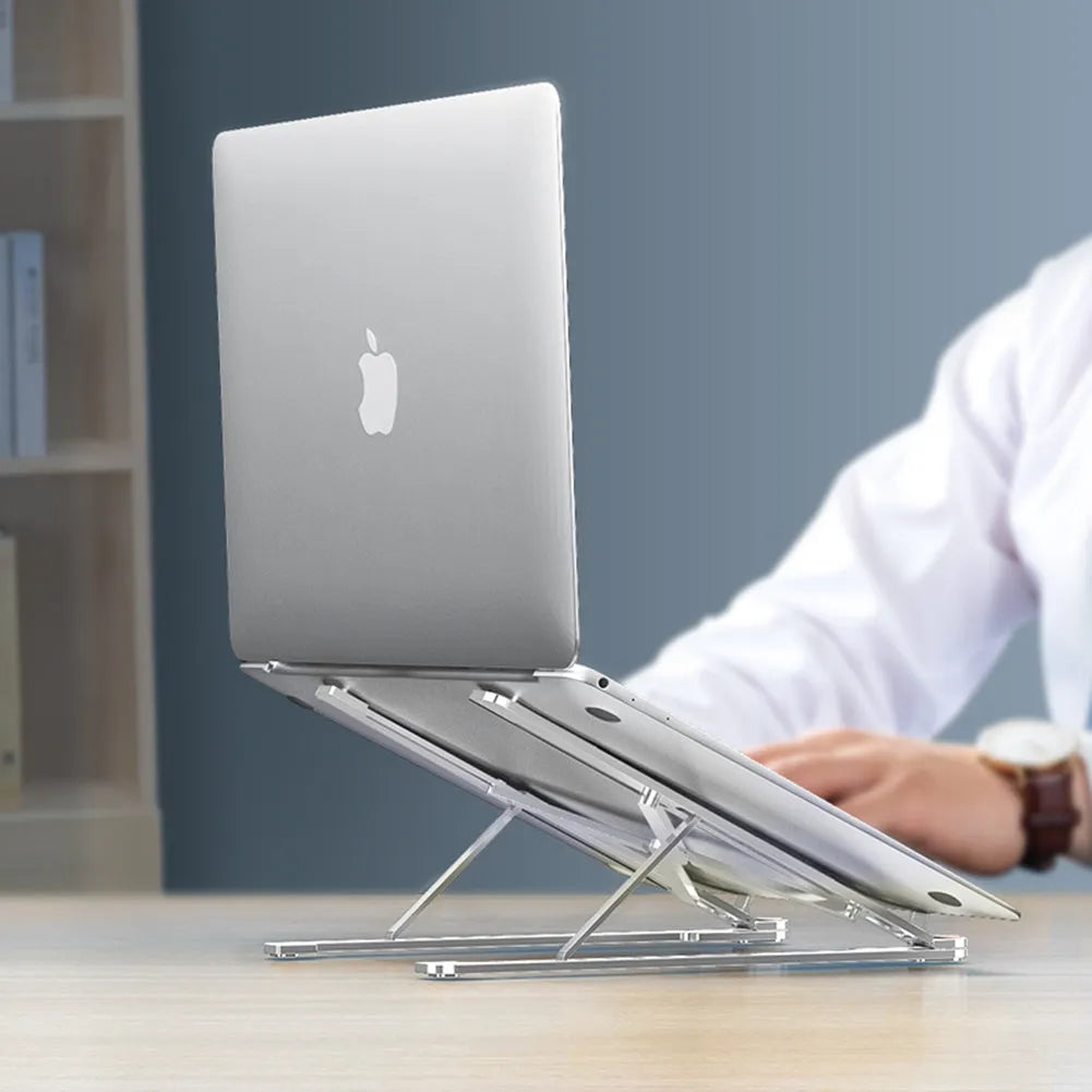 Aluminium laptop stand folded flat next to an open laptop showing adjustable height settings.
