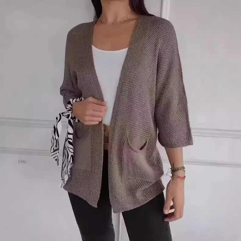 Women's army green waffle knit cardigan coat with nine-quarter sleeves and pockets laid flat.