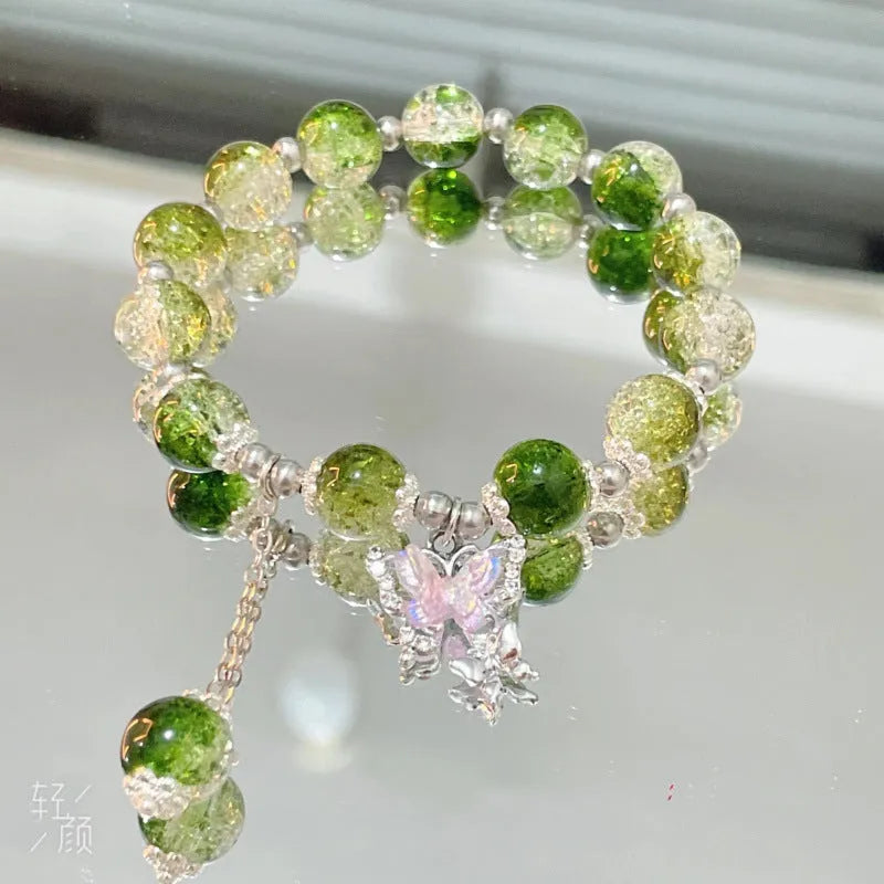 A Chinese style glass bracelet with bamboo leaf and bead designs on a wrist.