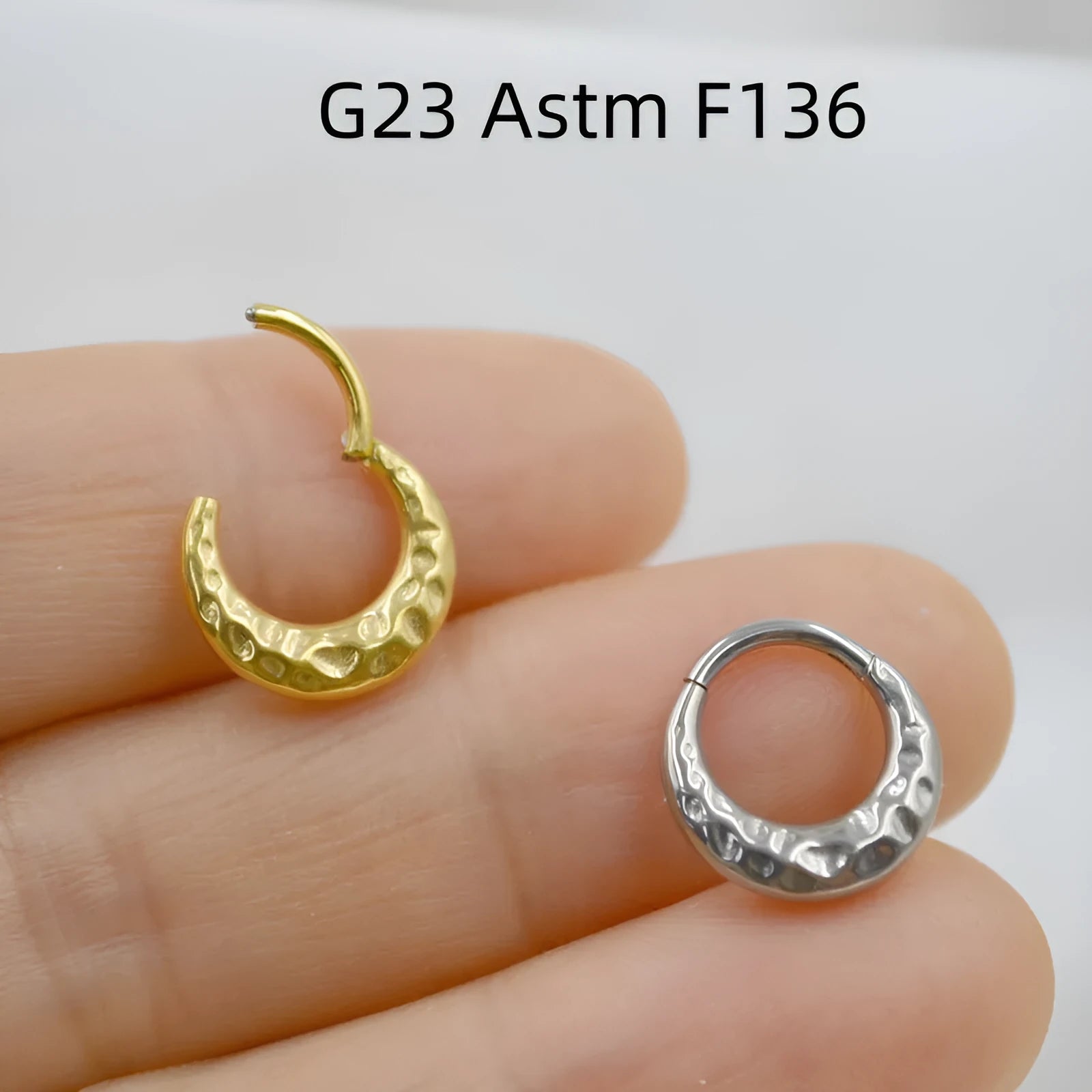 Close-up of a titanium alloy nose ring with concave-convex texture in a gold anodised finish.