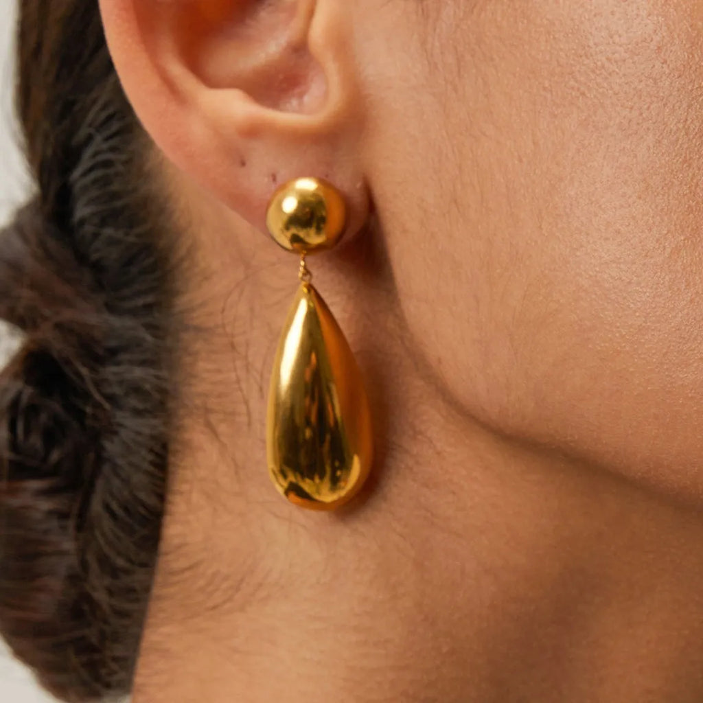 Gold coloured stainless steel earrings with geometric water drop hemisphere pendant design