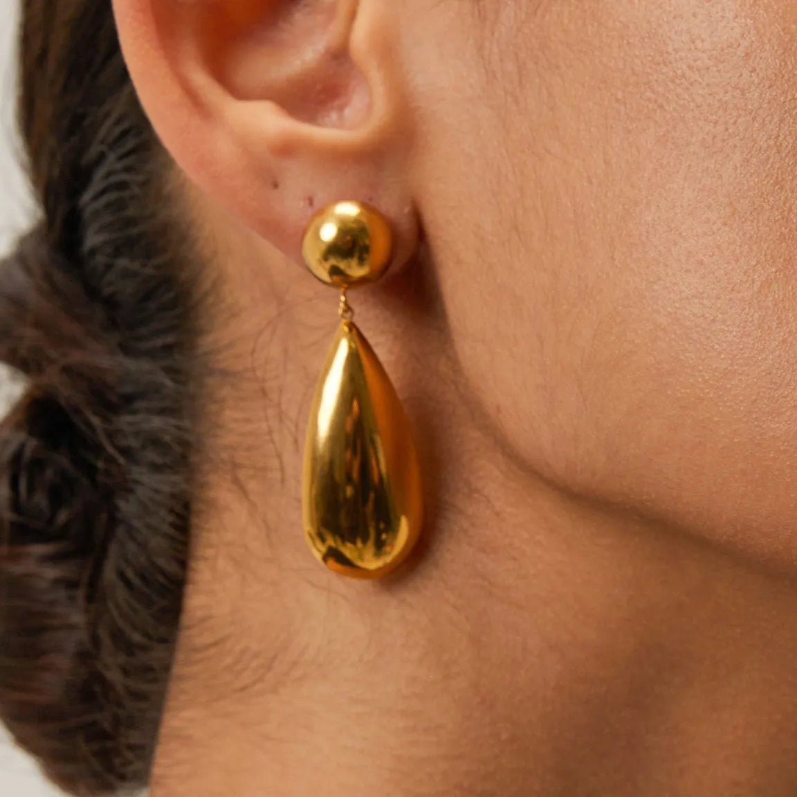 Gold coloured stainless steel earrings with geometric water drop hemisphere pendant design