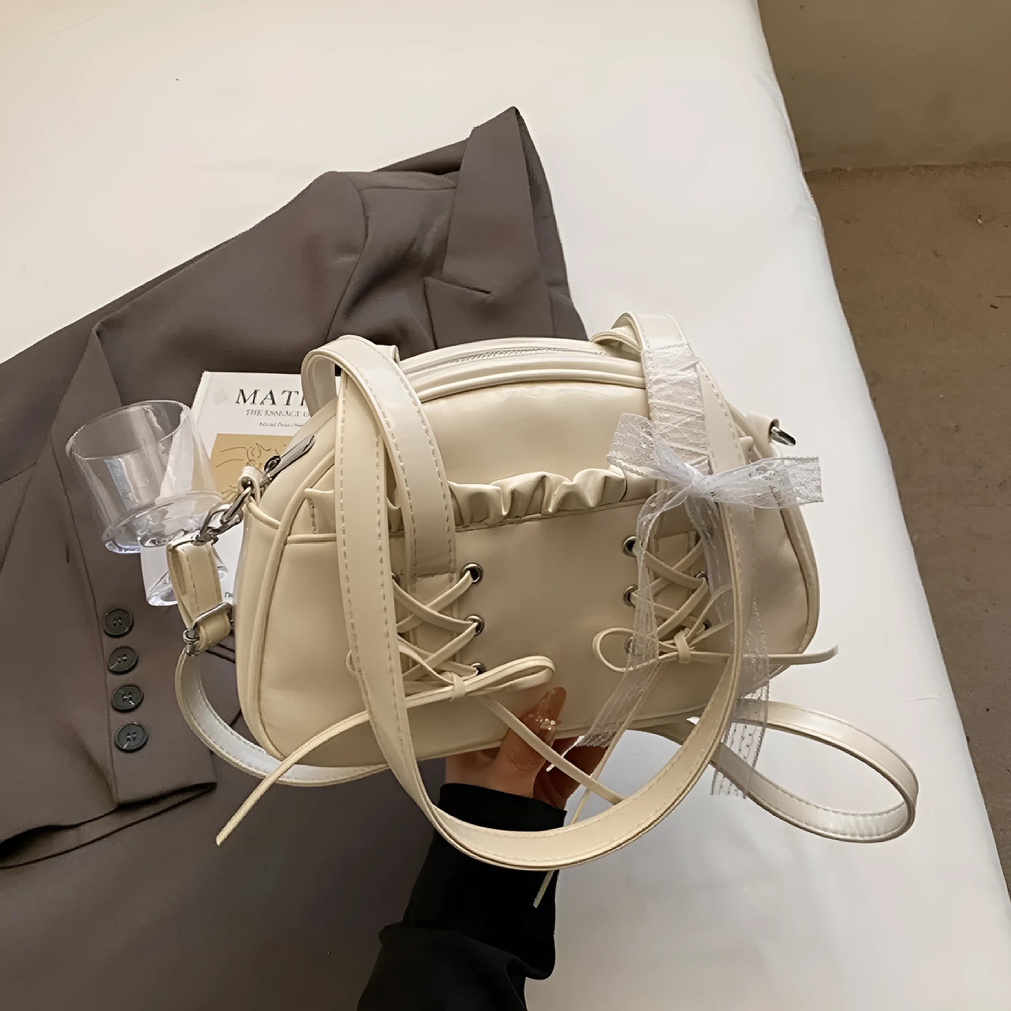 Women's white PU leather shoulder bag with a large bandage bow detail on the front.