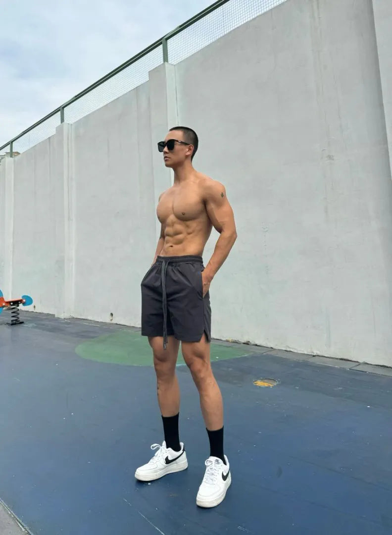 Men's ice silk quick-drying double-layer shorts in black, showing layered construction and casual fit