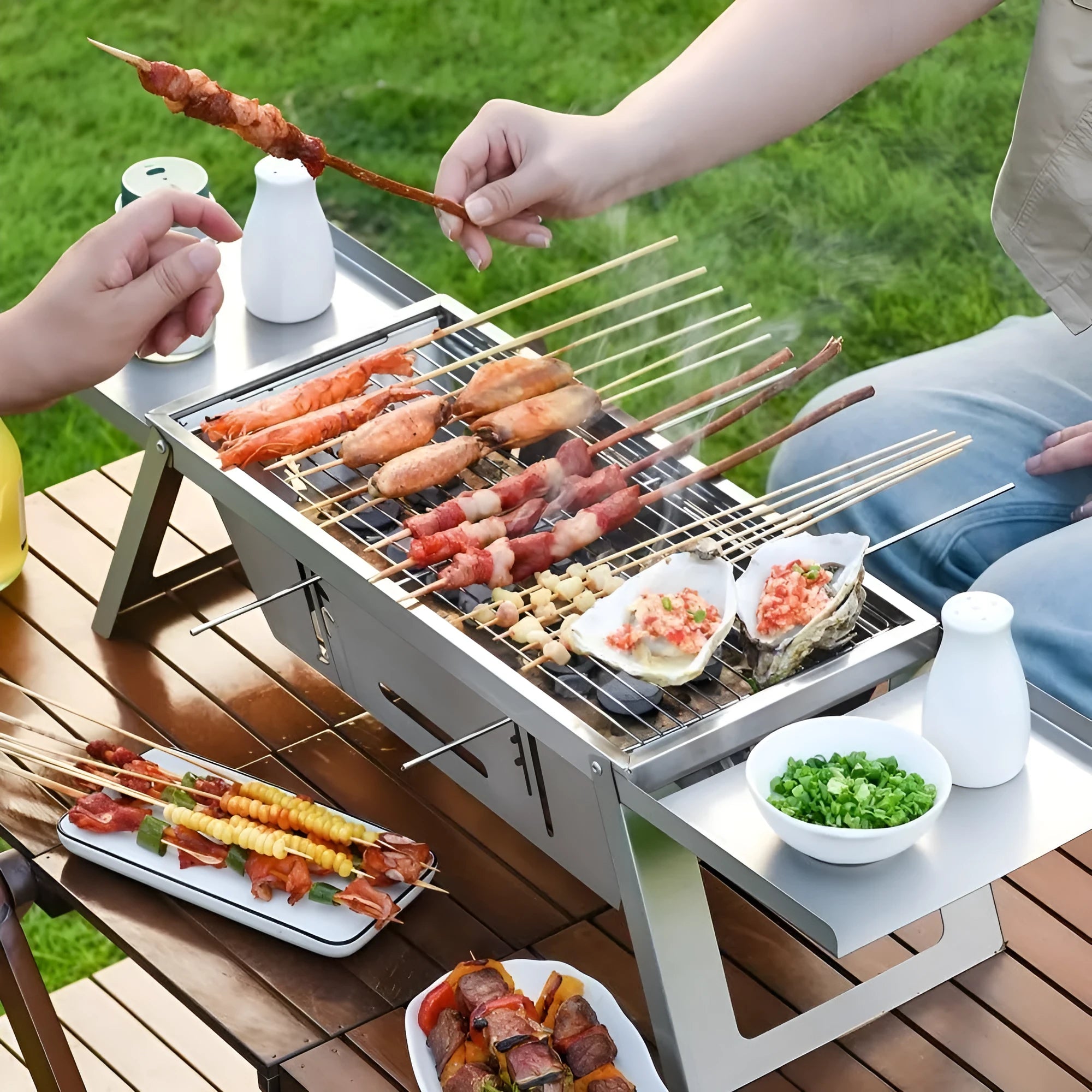 Small black foldable portable charcoal grill for outdoor barbecues, shown in both open and collapsed positions.