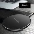 Black ultra-thin 9V QI wireless fast charger with USB cable on a desk.