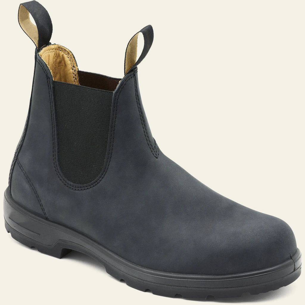 Vintage brown unisex Chelsea ankle boots with car suture stitching and a low heel on a wooden floor.