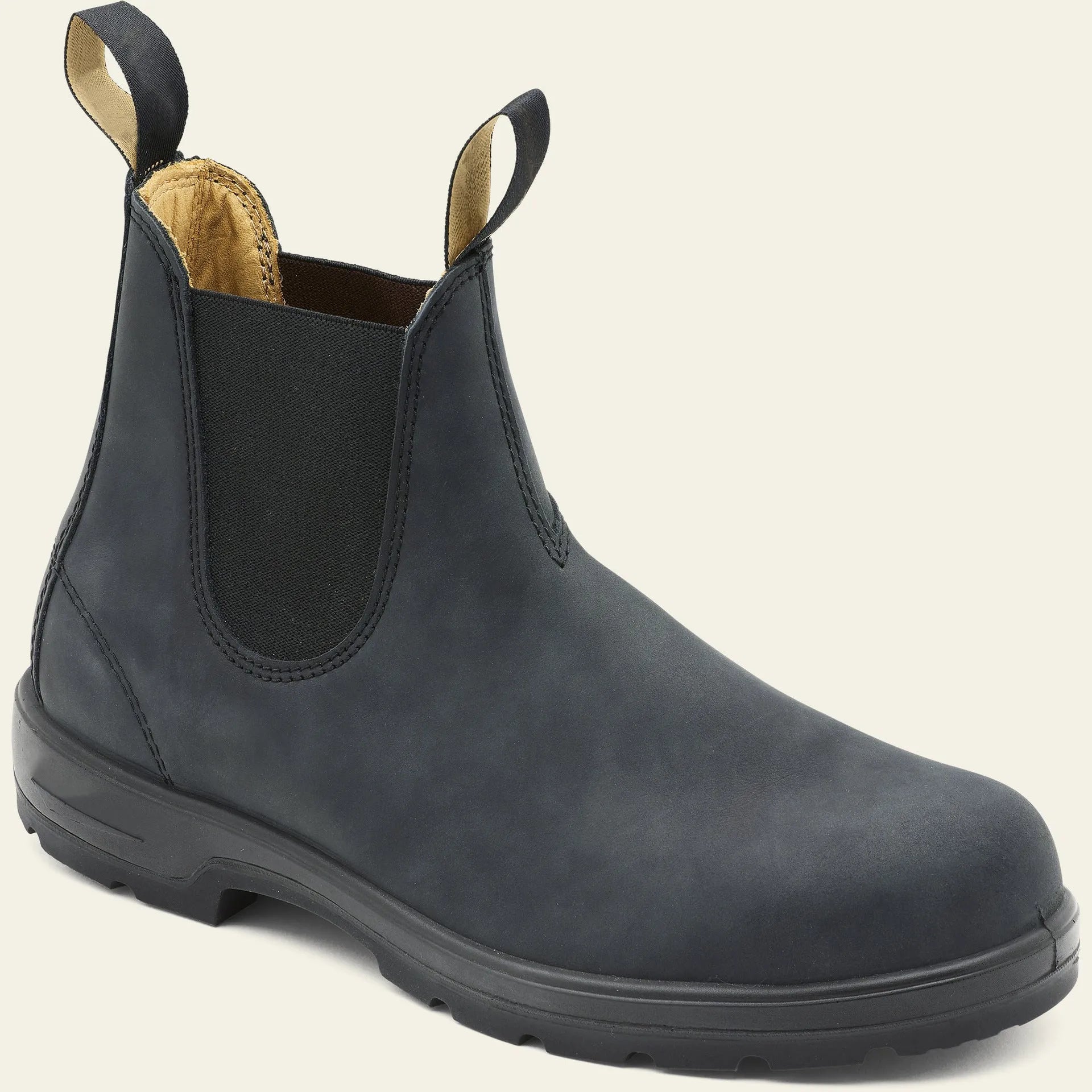 Vintage brown unisex Chelsea ankle boots with car suture stitching and a low heel on a wooden floor.