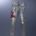 Men's vintage washed slim fit jeans with distressed holes and embroidered patch detail in old colour.
