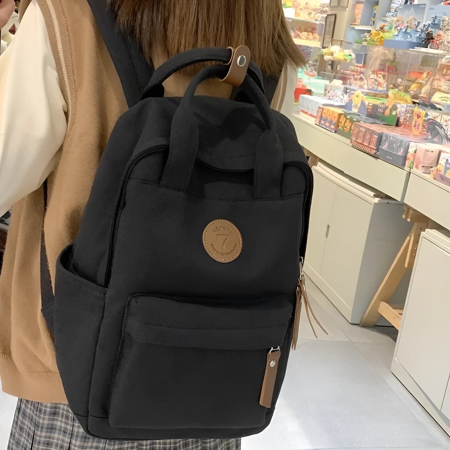 Black Oxford cloth leisure backpack with curved shoulder straps and retro sewing thread detailing