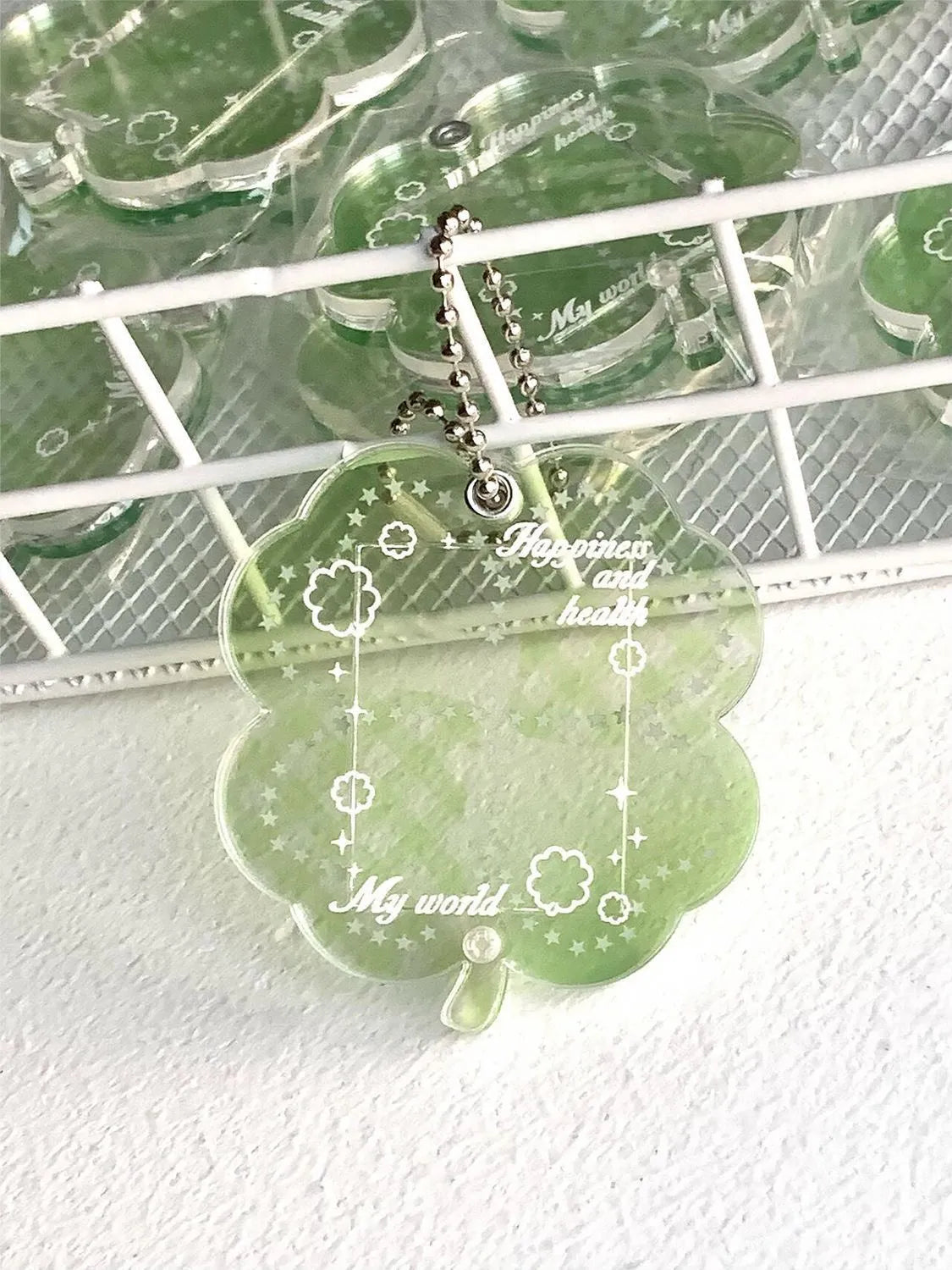 Acrylic four-leaf clover charm on a keychain for mobile phone decoration, shown in blue, green, and mint colour options.