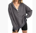 Loose fit women's raglan sleeve pullover sweater in a solid colour on a hanger.