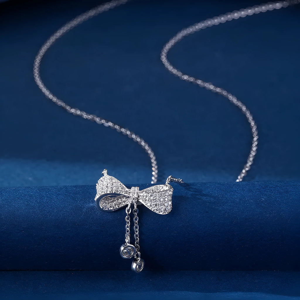 Silver bow necklace on adjustable chain showing pendant detail and polished finish