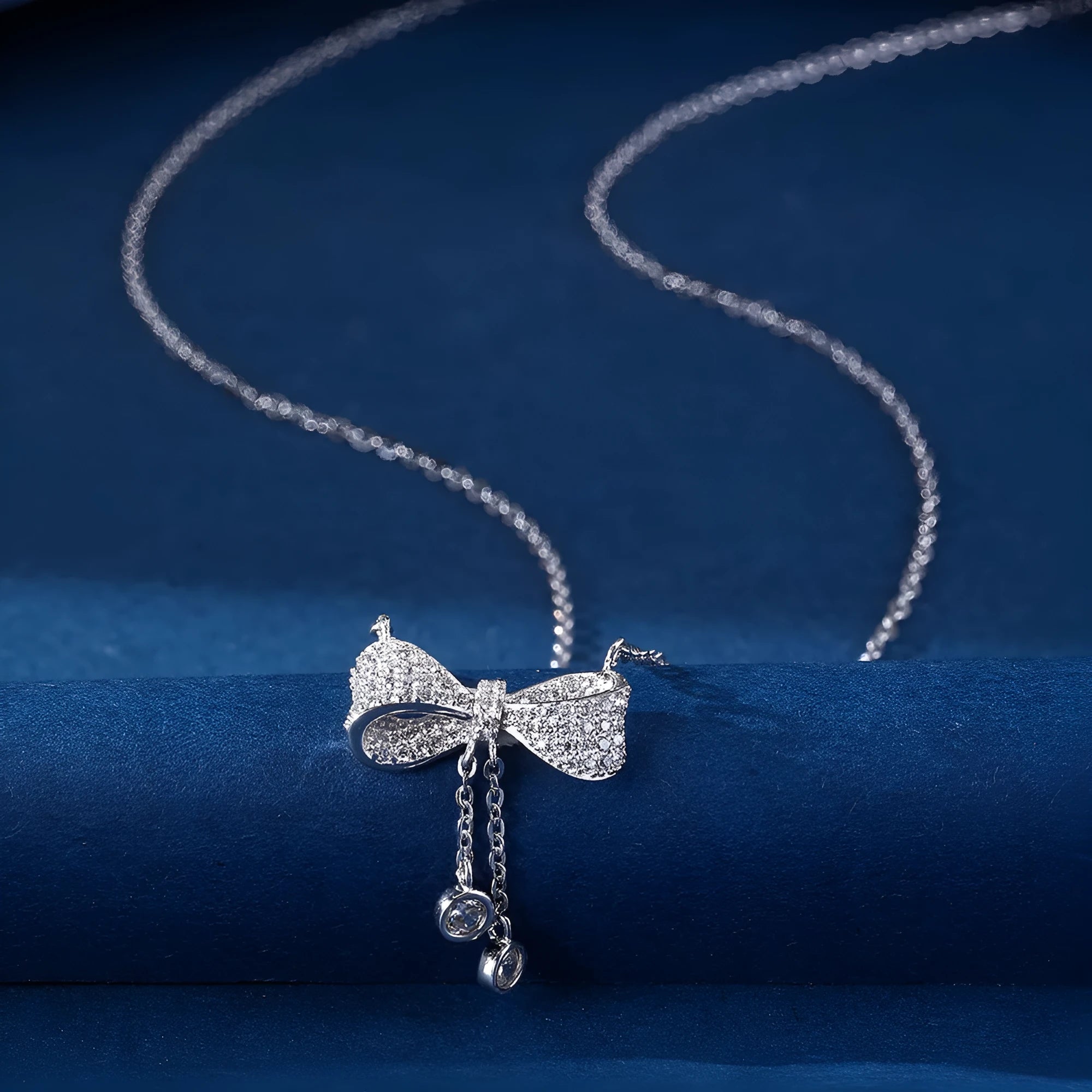 Silver bow necklace on adjustable chain showing pendant detail and polished finish