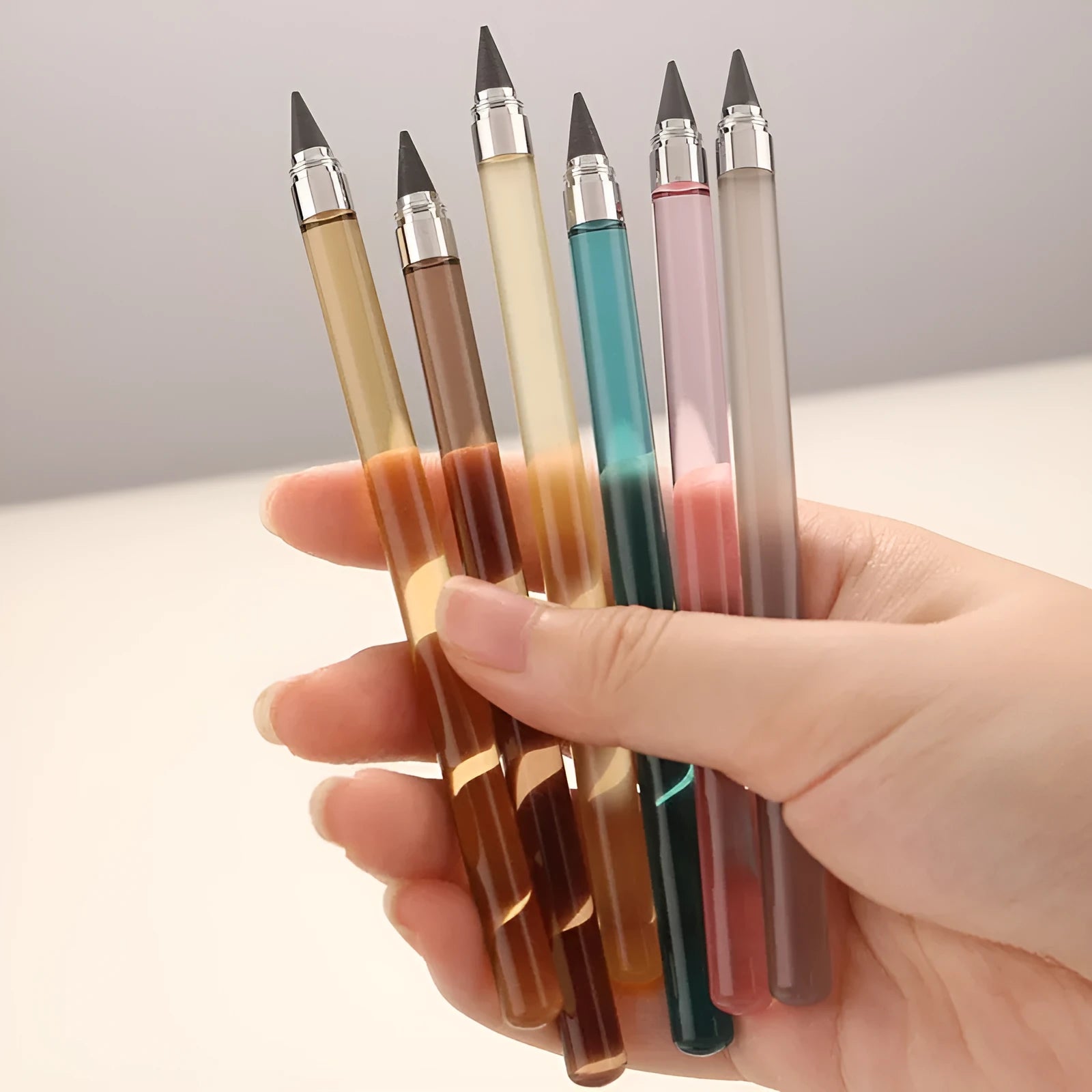 Transparent acrylic mechanical pencil with metal tip on a notepad.