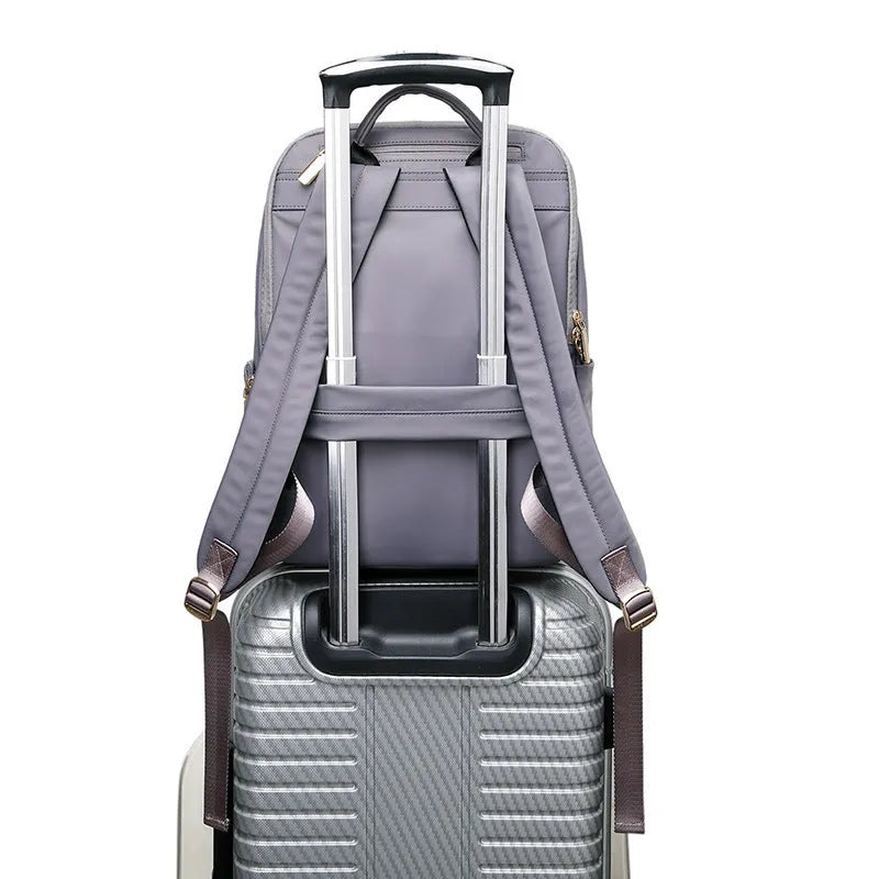 Large capacity Oxford cloth women's backpack in black and purplish grey, showing anti-theft and waterproof features.