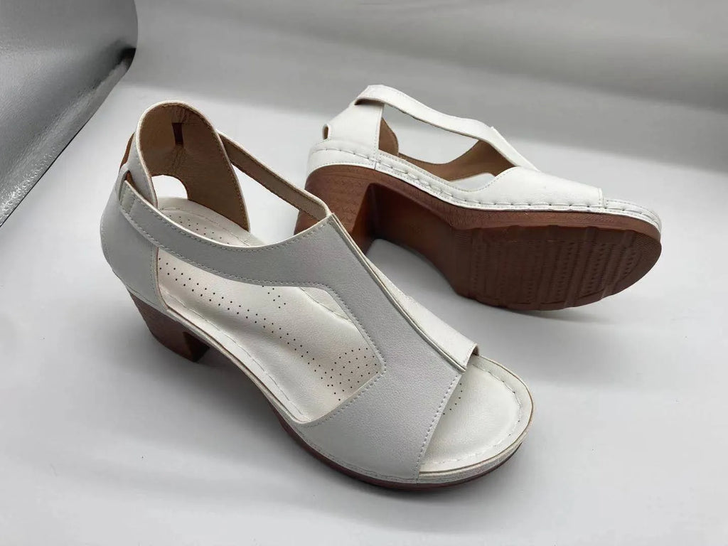 Women's beige peep toe wedge sandals with a Roman-style buckle strap on a low heel.