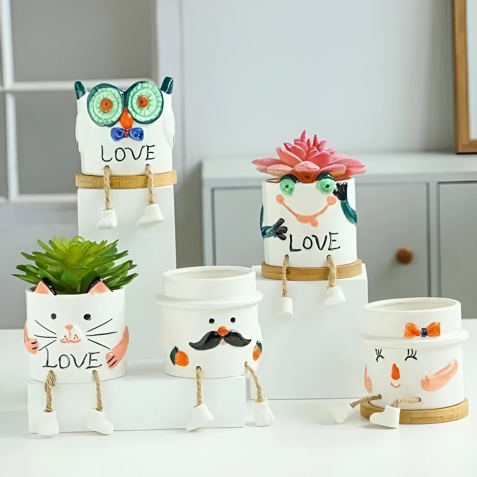 Ceramic cartoon-style succulent flowerpot with hanging foot design on desktop