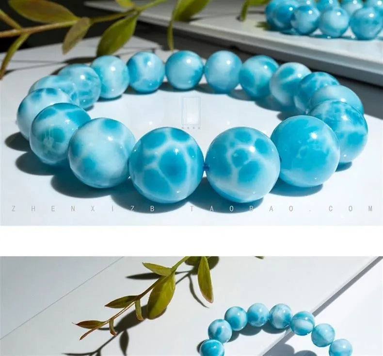 Blue natural crystal sea-pattern stone and bodhi seed bracelet with pearl accents on a wrist.