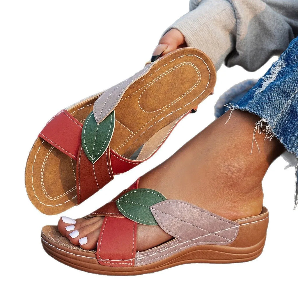 Black women's peep-toe slippers with a cross-strap design and a thick sole.