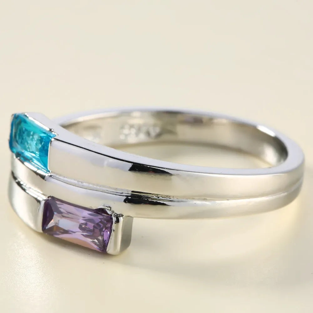 Silver-coloured copper ring with decorative zircon stone inlays on finger