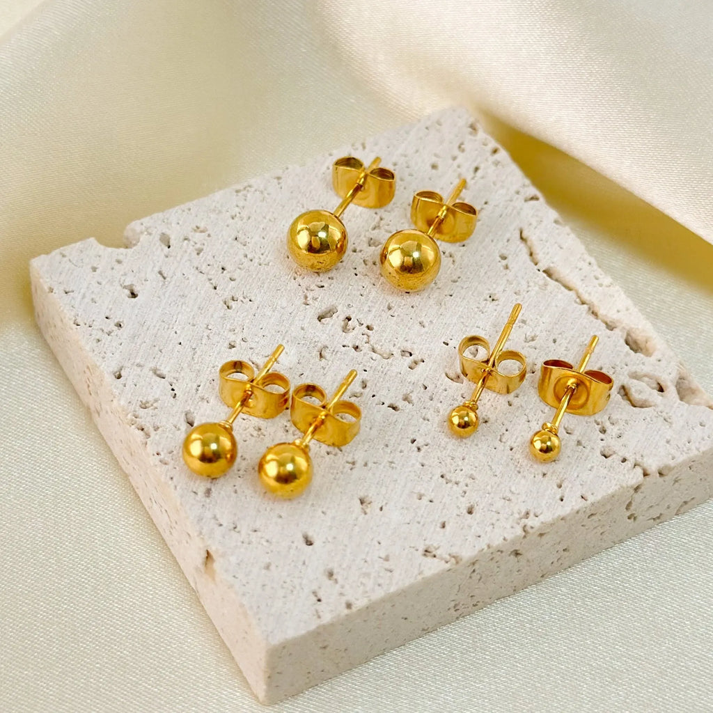 Gold and silver minimalist ball stud earrings in 3mm, 4mm, 5mm, and 6mm sizes on a plain background.