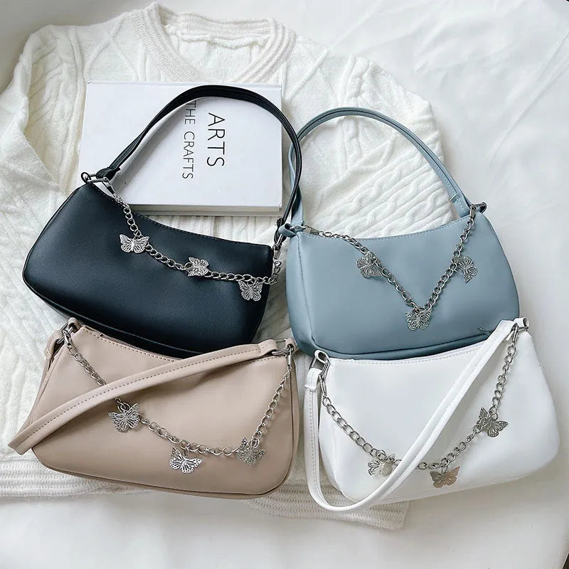 Women's black butterfly design chain underarm bag with a squared shape and three-dimensional pocket.