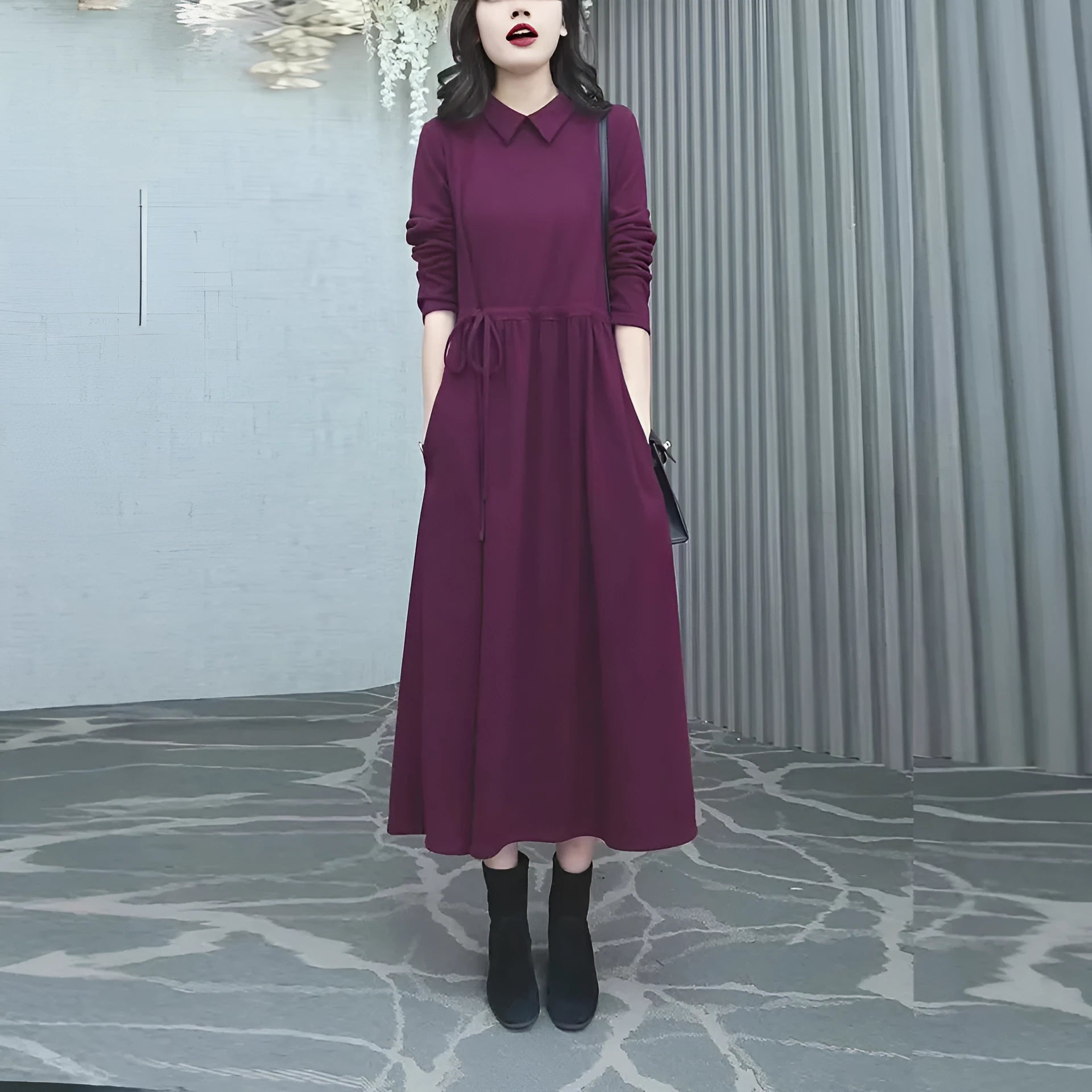 A purplish red plus size long sleeve dress with a long skirt, shown on a model.