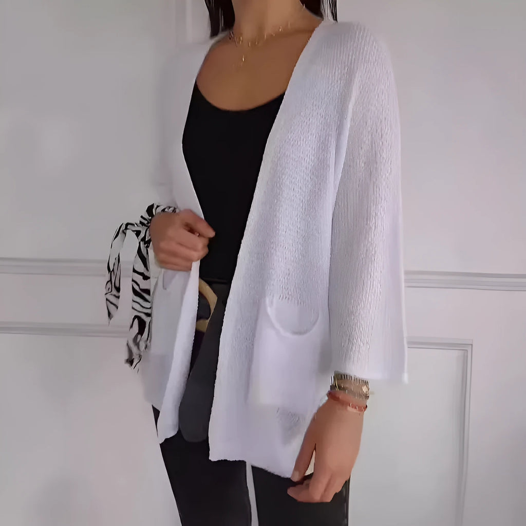 Women's army green waffle knit cardigan coat with nine-quarter sleeves and pockets laid flat.