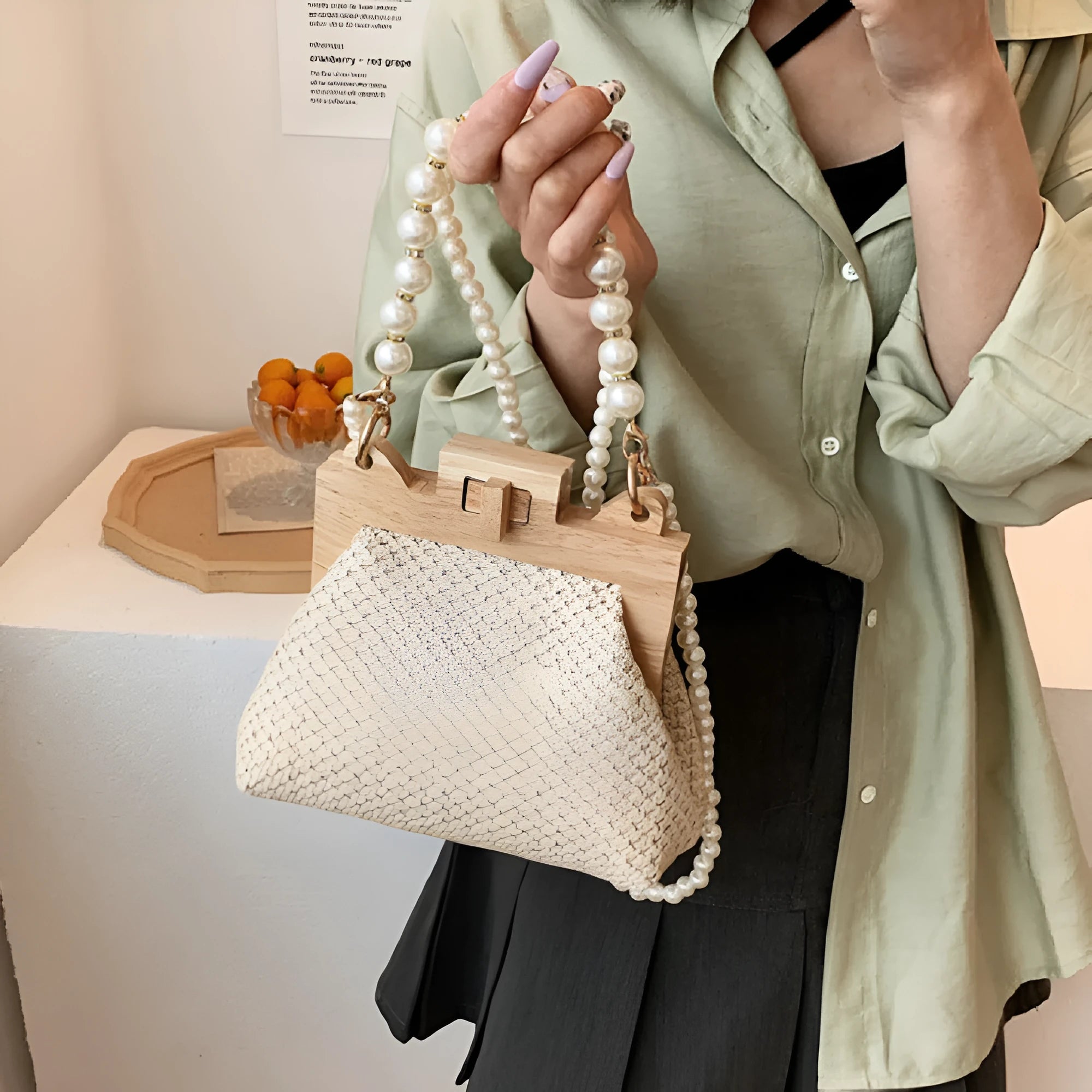 Women's soft straw woven horizontal square shoulder bag with pearl chain strap in beige colour.