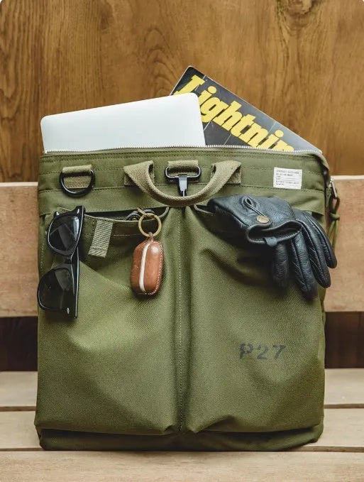 Canvas crossbody messenger bag in military green with shoulder strap and hard handle showing laptop compartment