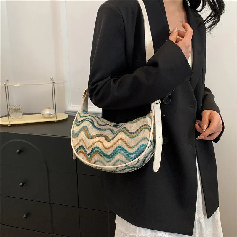 Women's woven straw crossbody bag showing internal phone and document compartments