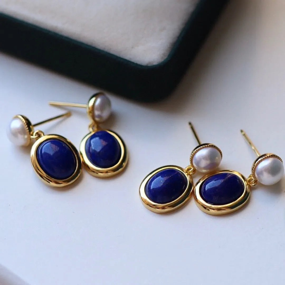 A pair of simple stud earrings featuring a deep blue lapis lazuli pearl set in 925 silver.