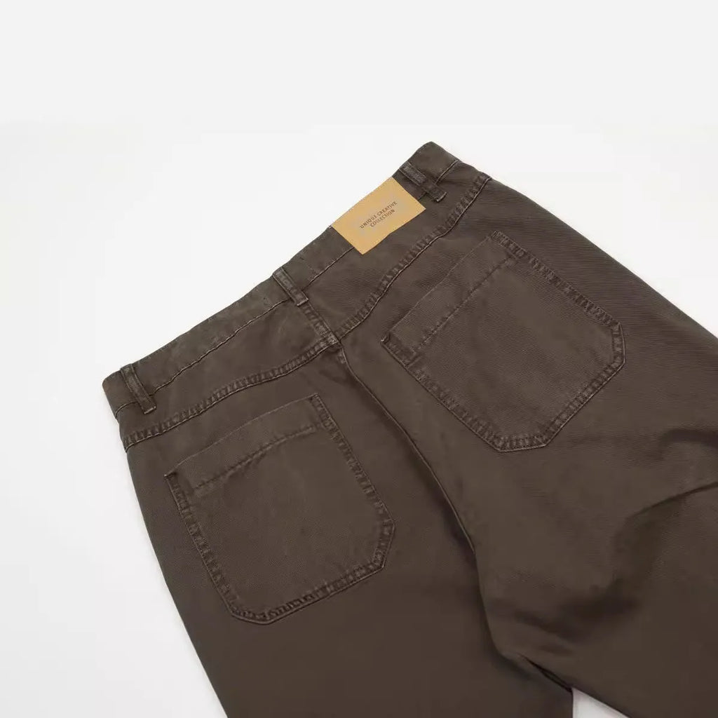 Men's brown loose fit straight leg cotton jeans with a high waist and zip fly on a hanger.