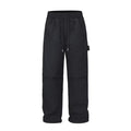 Black paratrooper trousers with elastic waist and drawstring closure, showing baggy fit and three-dimensional cutting