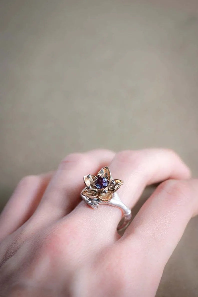 Silver two-tone women's floral ring with a simple geometric shape on a neutral background.
