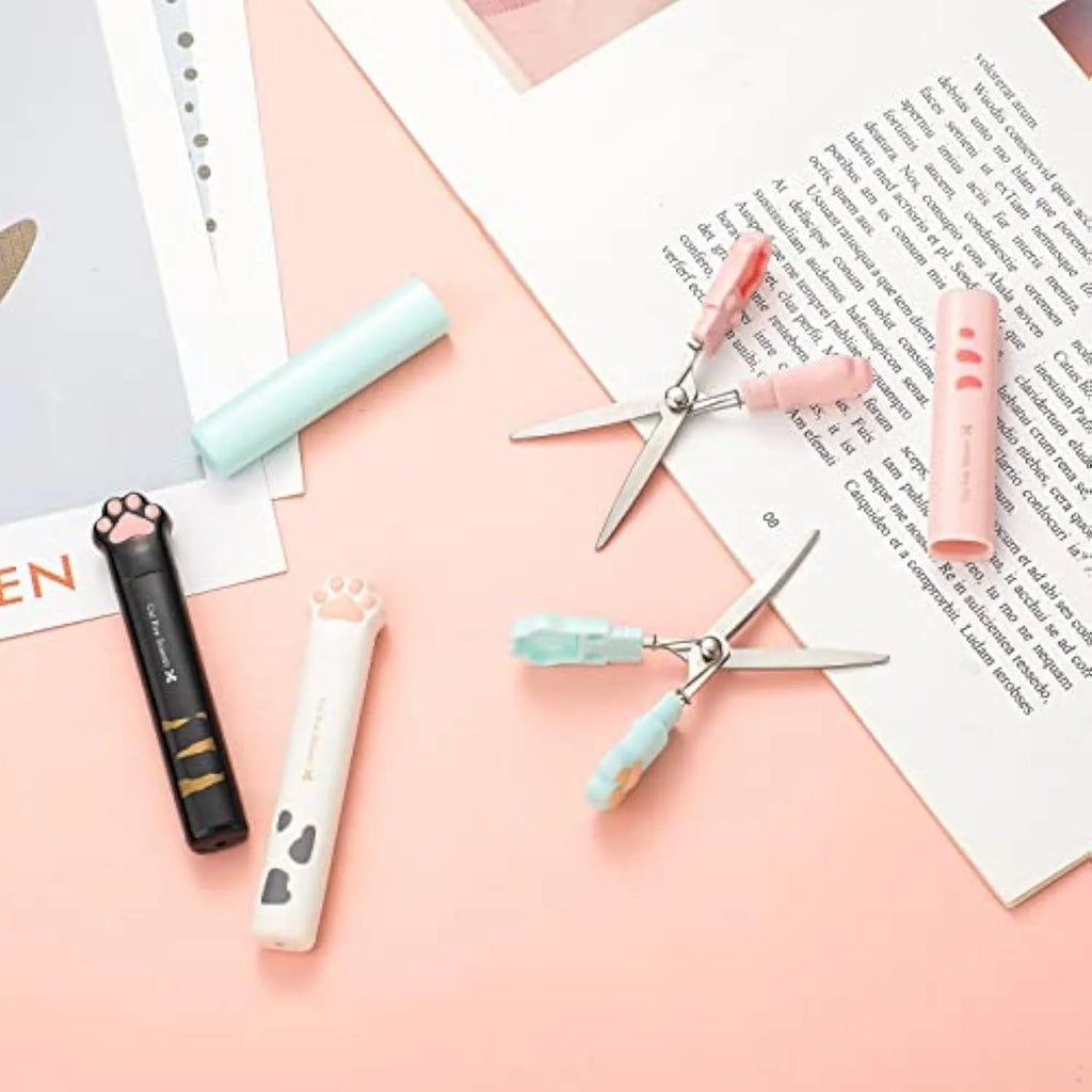 Set of four mini folding scissors with cat paw design in black, blue, pink, and white colours.