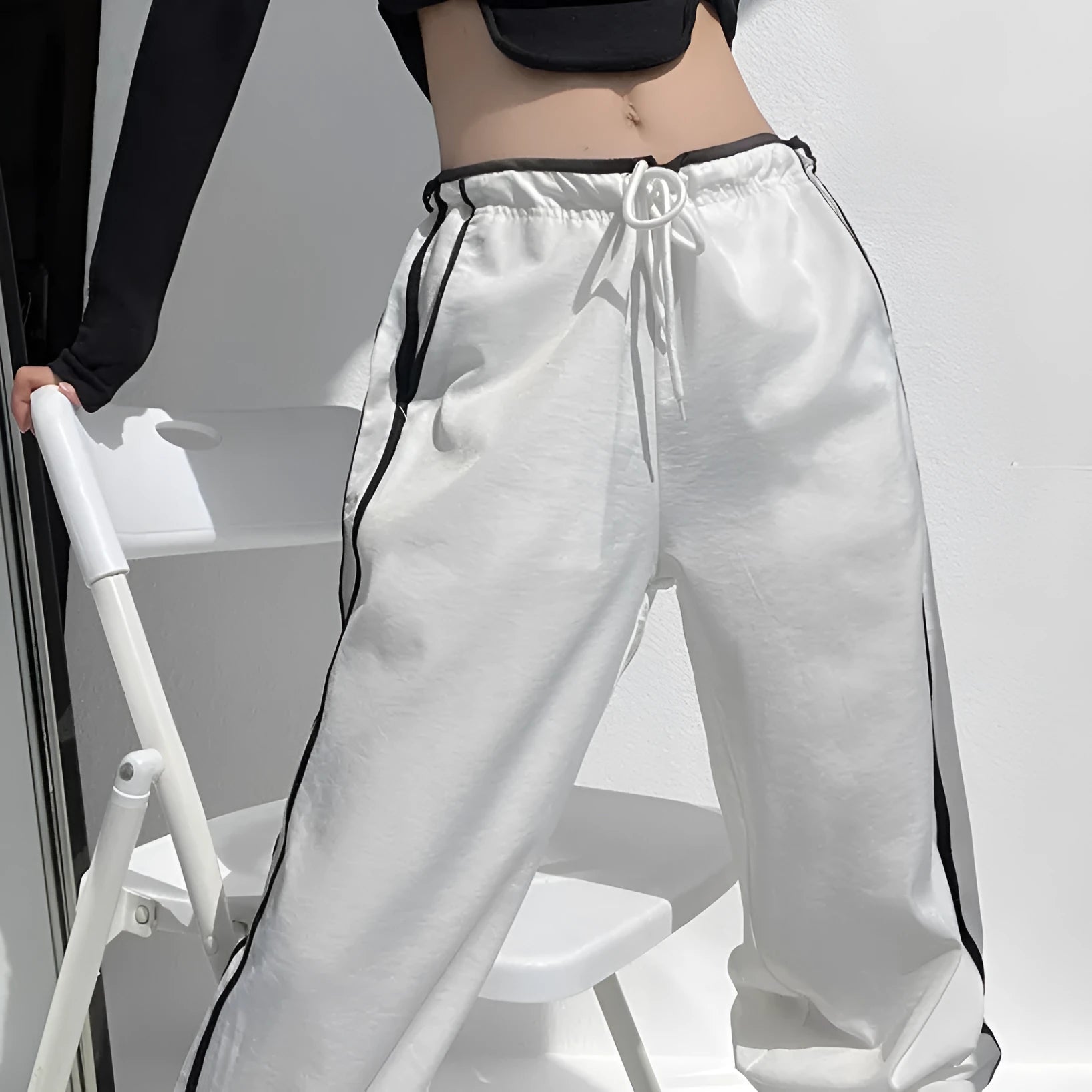 Navy blue loose straight-leg trousers with ribbon-adjustable waist and parallel bars design detail.