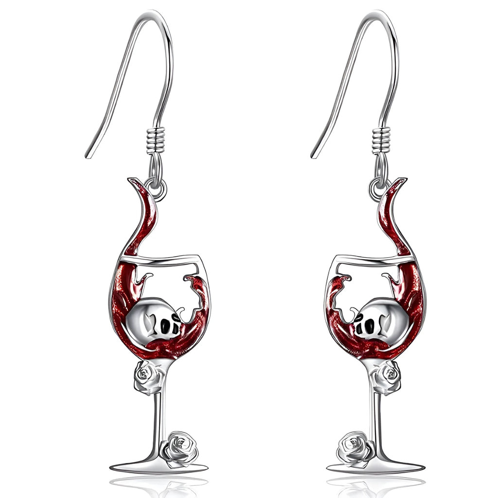 A pair of silver-toned Halloween earrings combining a skull design with a wine glass shape.