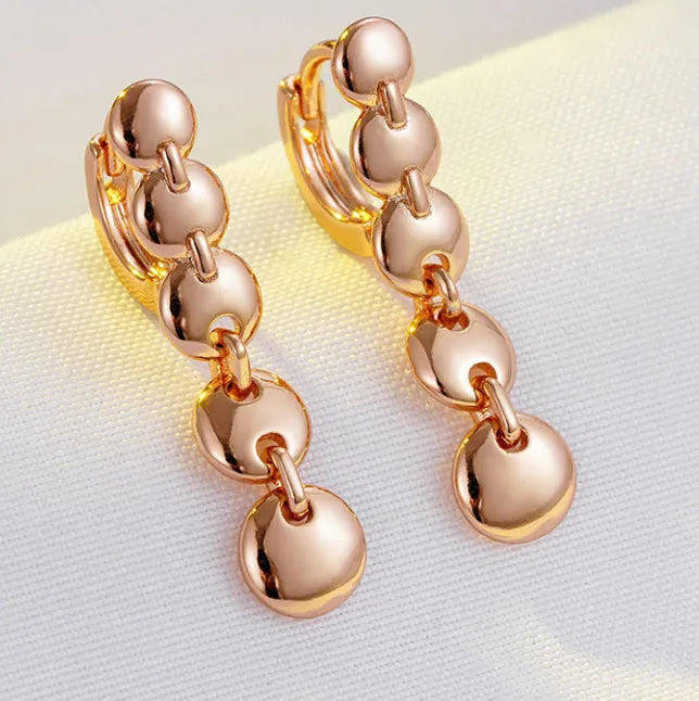 Retro long round copper earrings with woven design in a gold colour finish.