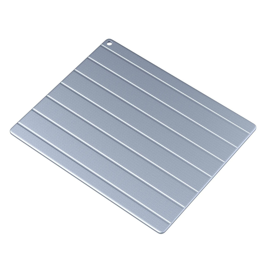 A modern aluminium household defrosting plate with a USB cable on a kitchen worktop.