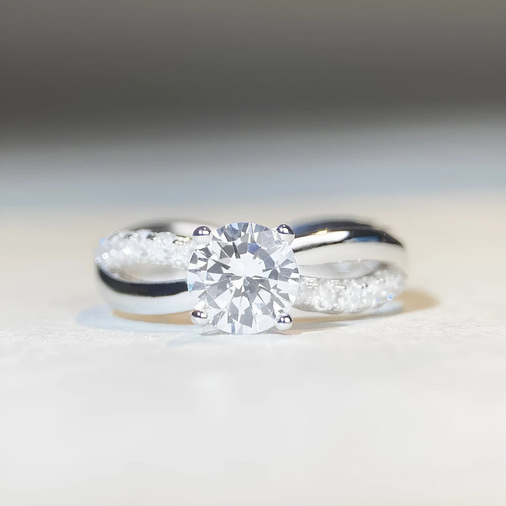Geometric cross-design silver ring with a 1 karat moissanite stone in a four-claw setting.