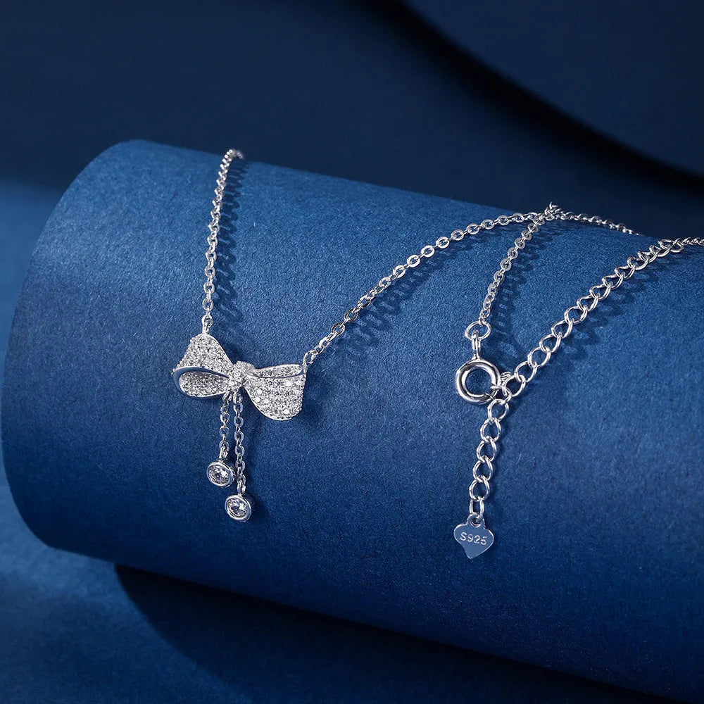 Silver bow necklace on adjustable chain showing pendant detail and polished finish