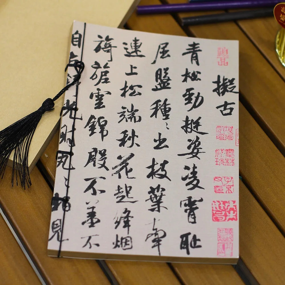 A5 antique wire-bound notebook with retro painting cover, thread binding, and black tassels.