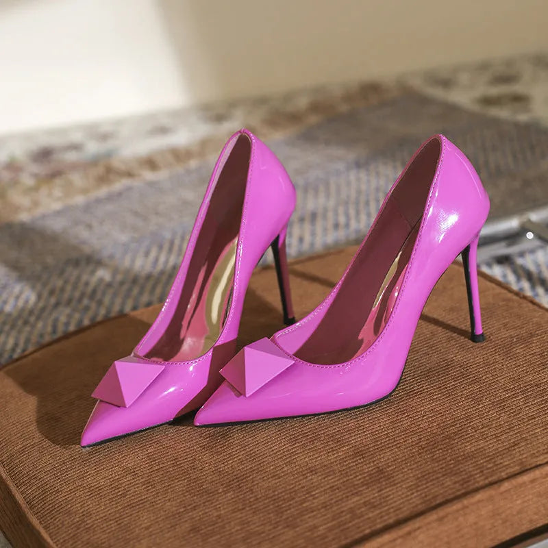 Women's pink patent leather stiletto heels with pointed toe and buckle fastening on rubber sole