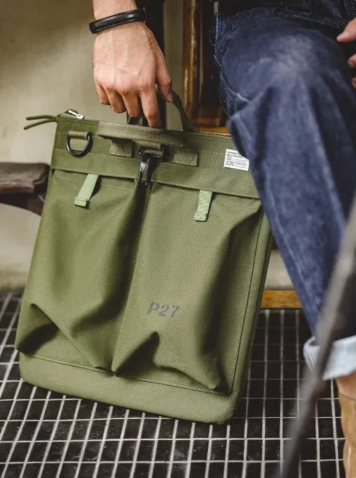 Canvas crossbody messenger bag in military green with shoulder strap and hard handle showing laptop compartment