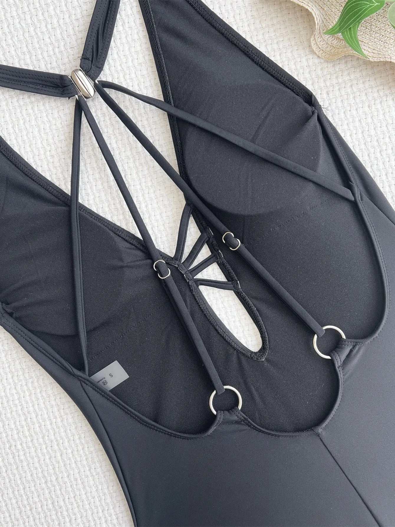 Ladies solid black one-piece nylon bikini swimsuit laid flat.
